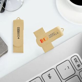 Two beige eco swivel drives printed with a logo lying beside a laptop keyboard and a coffee cup