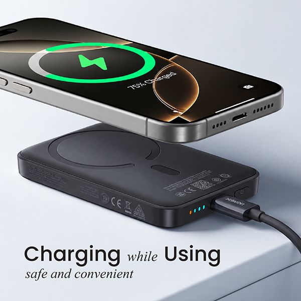 Phone charging wirelessly on top of the black magnetic power bank while a cable is plugged into its Type-C port