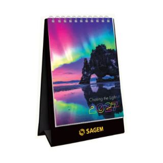 Chasing the Light desk calendar standing closed on its black card stand, cover showing aurora photography