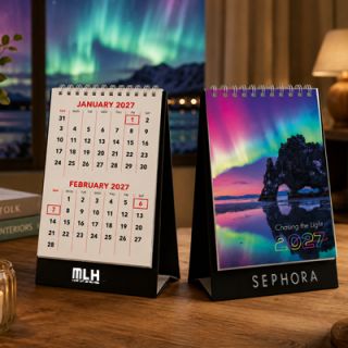 Two Chasing the Light desk calendars on a desk, one closed at the cover and one open at a monthly page
