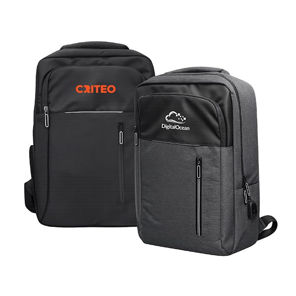 Black and grey backpacks with vertical front zip pockets, side charging ports and logos printed on the upper front panel.