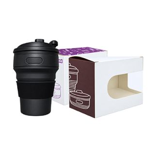 Black collapsible cup with flip lid standing next to its white window gift box