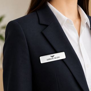 Woman in a black blazer wearing a white epoxy coated acrylic name tag
