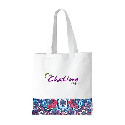 White canvas tote bag with two long shoulder handles, a blue and red floral band printed across the lower front panel and a sample logo printed on the plain area above it