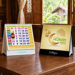 Two Kalendar Hijrah desk calendars on a desk, one closed at the cover and one open at a monthly page