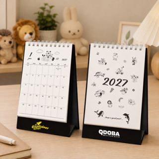 Two animal doodle desk calendars on a desk, one closed at the cover and one open at a monthly page