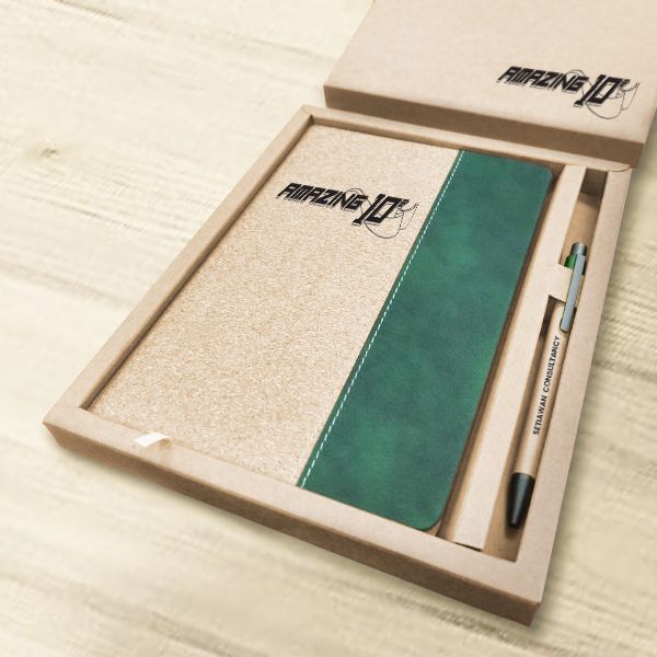 Close-up of the open kraft box holding the cork notebook with a green velvet band and the eco paper pen in its own slot, both printed with a sample logo