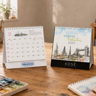Two Timeless Destinations desk calendars on a desk, one closed at the cover and one open at a monthly page
