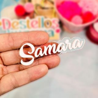 Hand holding a clear acrylic name tag die-cut around white script lettering